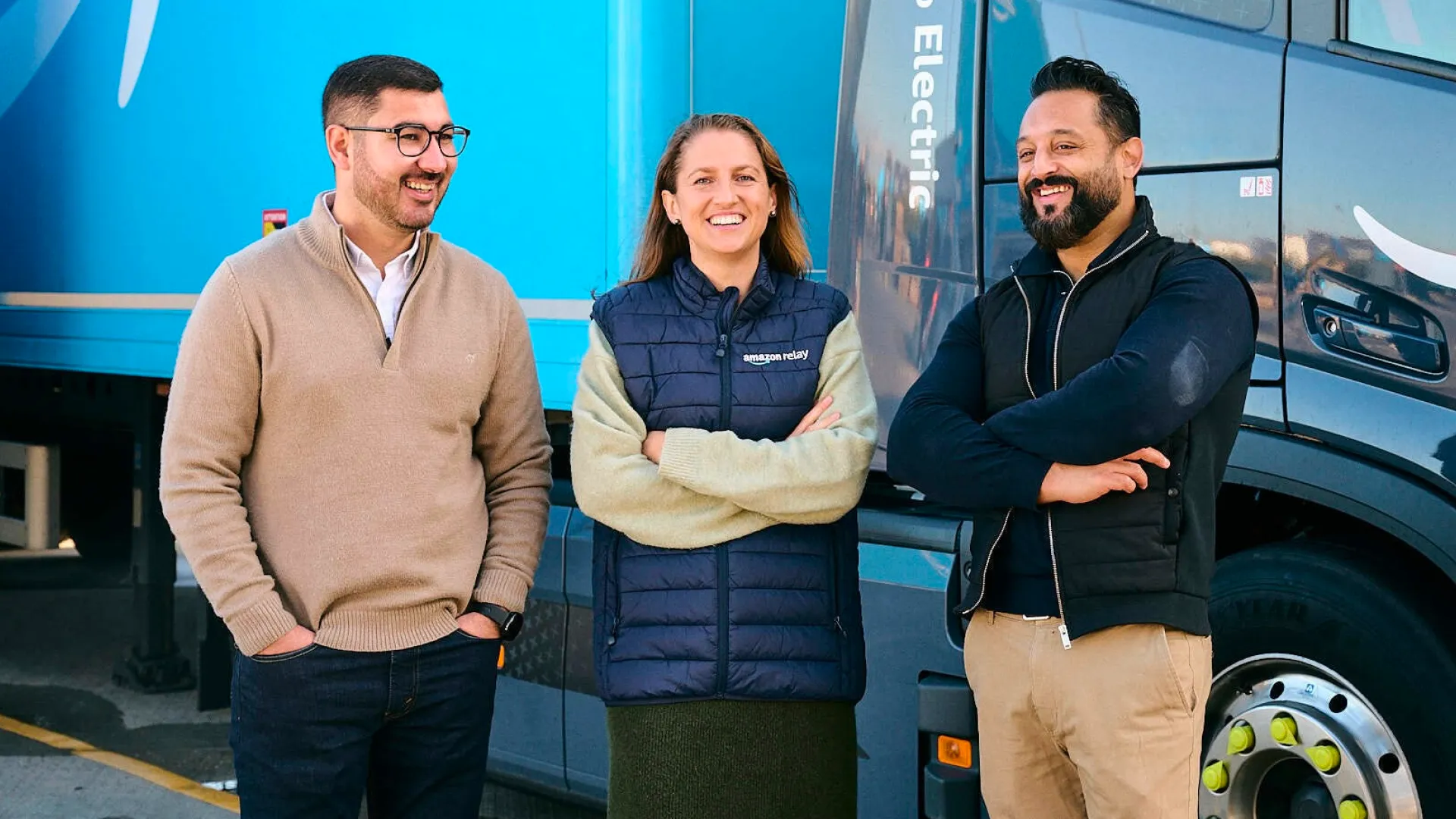 Three smiling Amazon Freight Partners drivers posed in front of their branded delivery truck